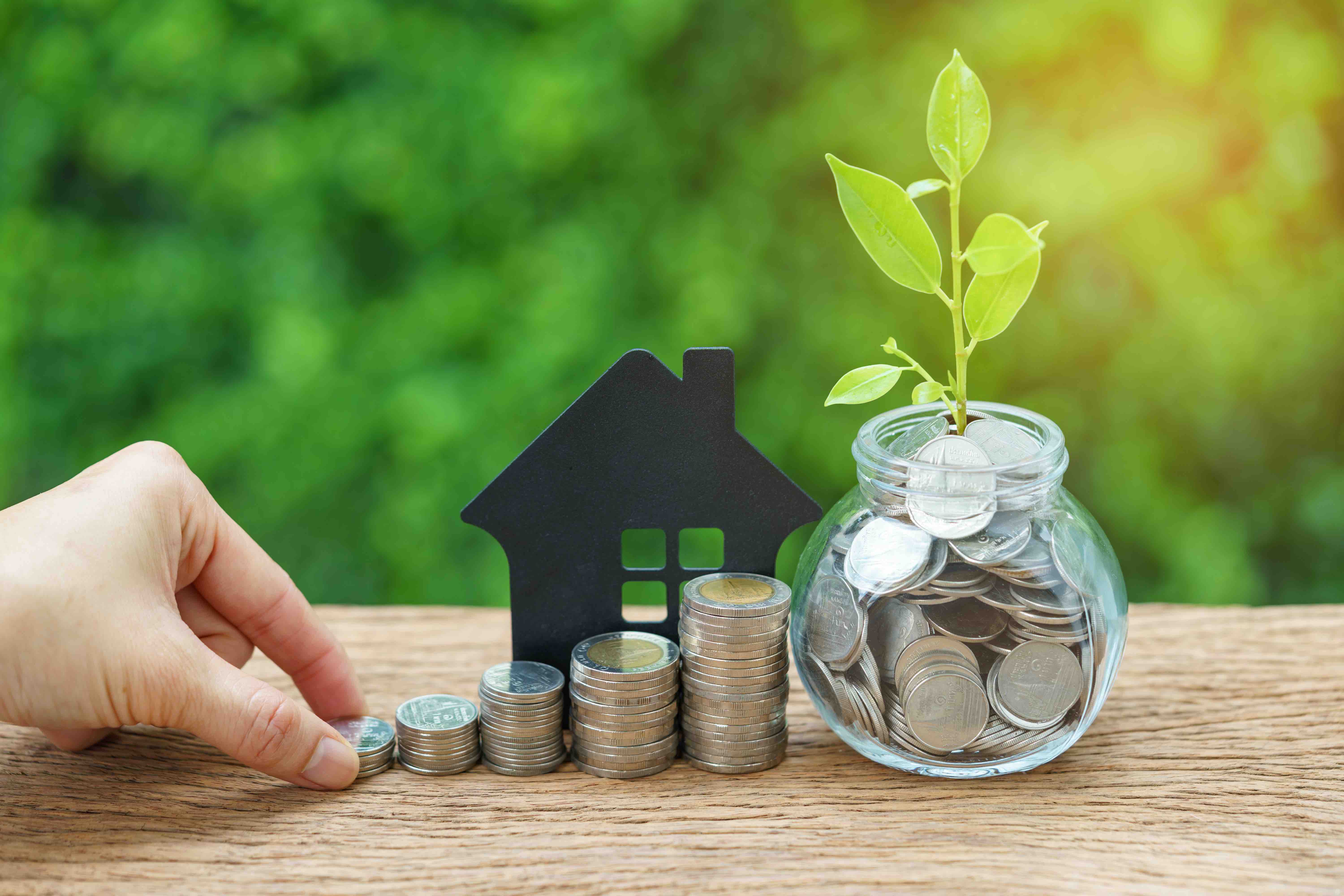 growth sprout plant in jar with full of coins and hand holding stack of coins with paper house as property or mortgage investment concept AMIENS, à 2 pas de la gare